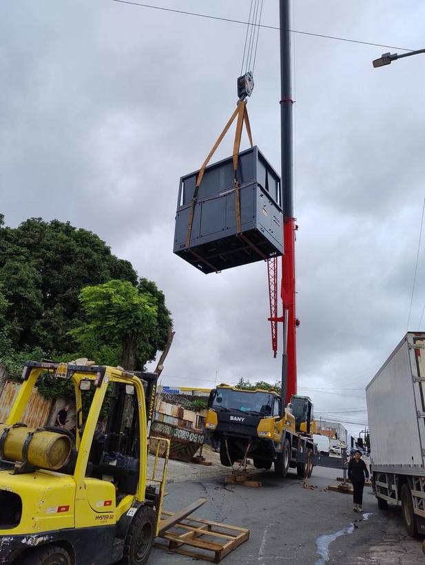 Equipamento industrial içado por guindaste com a empilhadeira Fox dando apoio