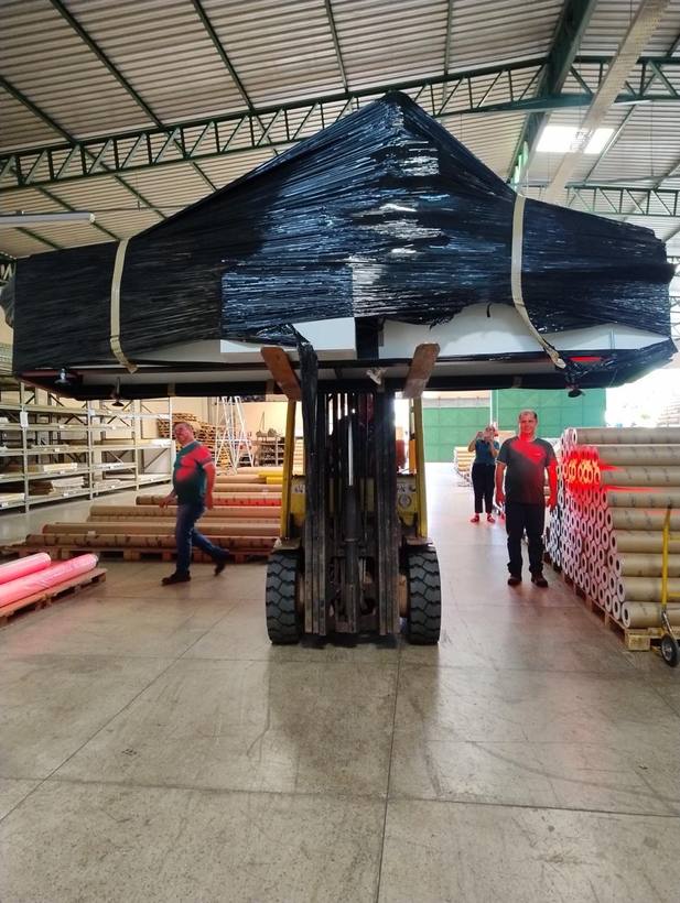 Empilhadeira Fox movimentando peça larga embalada dentro de galpão industrial