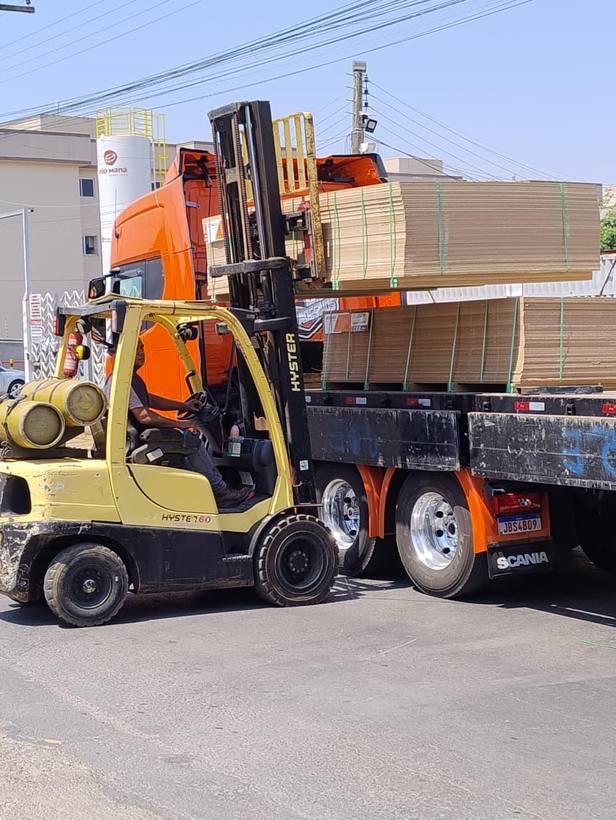 Empilhadeira Fox descarregando pacotes de chapas de um caminhão